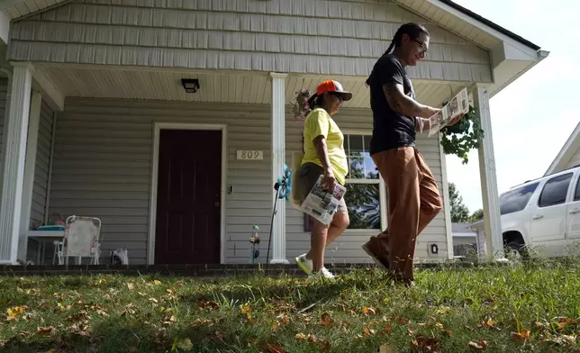 Salvador Fonseca, right, and Elena Jimenez leave a home during a voter engagement event for the Latino community in Greensboro, N.C., Saturday, Sept. 21, 2024. (AP Photo/Chuck Burton)