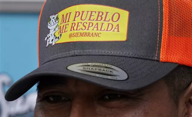 A volunteer with Siembra NC, a support group for Latinos, wears a hat that says "my people support me" during a voter engagement event for the Latino community in Greensboro, N.C., Saturday, Sept. 21, 2024. (AP Photo/Chuck Burton)