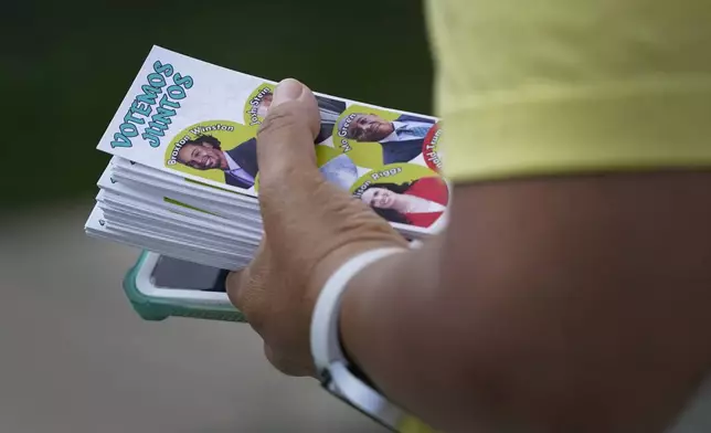 Elena Jimenez carries a voting guide during a voter engagement event for the Latino community in Greensboro, N.C., Saturday, Sept. 21, 2024. (AP Photo/Chuck Burton)