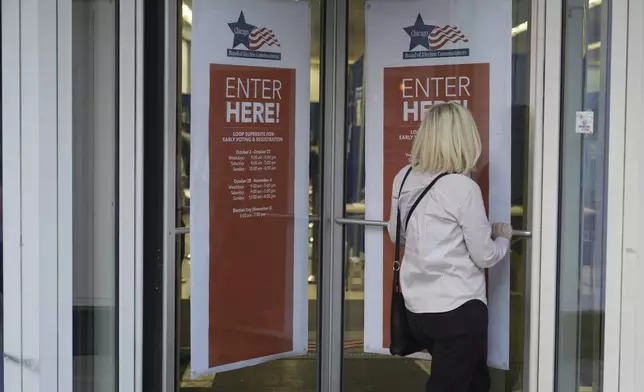 A person walks in to register on the first day of early voting for the 2024 Presidential General Election, Thursday, Oct. 3, 2024 in Chicago. (AP Photo/Charles Rex Arbogast)