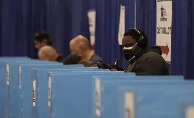 People check in on the first day of early voting for the 2024 Presidential General Election, Thursday, Oct. 3, 2024 in Chicago. (AP Photo/Charles Rex Arbogast)