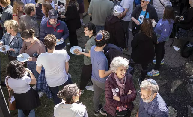 Supporters of Democratic presidential nominee Vice President Kamala Harris gather around a Sukkot before going door to door canvassing Jewish voters during the Jewish holiday in Bala Cynwyd, Pa, Sunday, Oct. 20, 2024. (AP Photo/Laurence Kesterson)