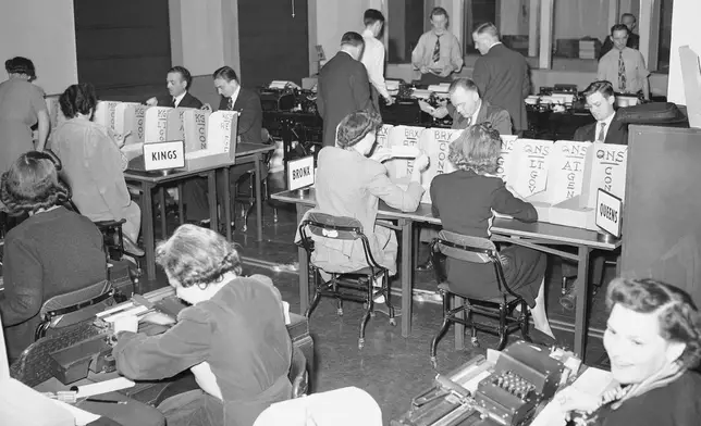 FILE - Tabulators record the Associated Press election returns in the offices of IBM in New York City on Election Day, Nov. 3, 1942. The returns are received on the teletype machines (background) and recorded with the aid of the numeric punching and printing machines in the foreground. (AP Photo/Matty Zimmerman, File)