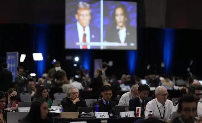 FILE - Members of the press work in the spin room during a presidential debate between Republican presidential nominee former President Donald Trump, on screen at left, and Democratic presidential nominee Vice President Kamala Harris, right, Sept. 10, 2024, in Philadelphia. (AP Photo/Matt Slocum, File)