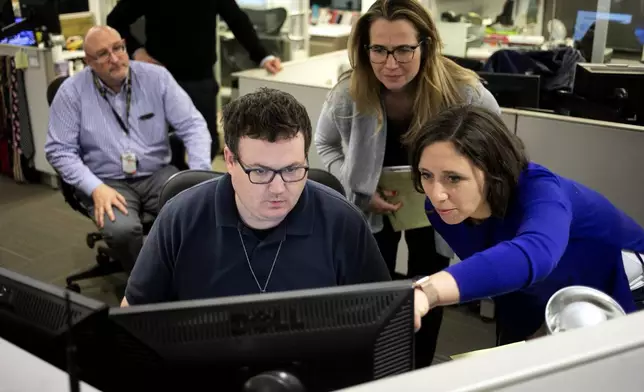 FILE - Associated Press Washington Bureau Chief Julie Pace, right, looks over a headline with deputy managing editor for operations David Scott in the newsroom at the Associated Press in Washington, Feb. 5, 2020. (AP Photo/Jenny Kane, File)