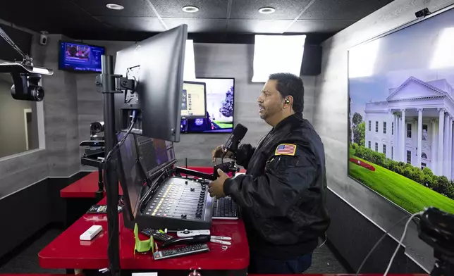 Radio host and owner of radio station La Mega 101.7 FM Victor Martinez on the air in Allentown, Pa., Tuesday, Oct. 15, 2024. (AP Photo/Ryan Collerd)