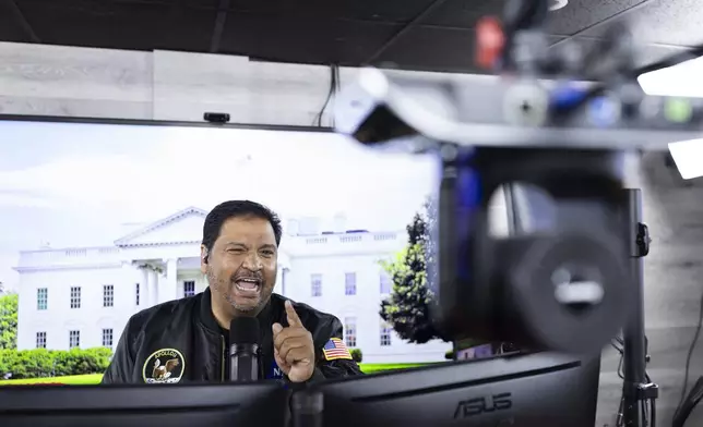 Radio host and owner of radio station La Mega 101.7 FM Victor Martinez speaks on the air in Allentown, Pa., Tuesday, Oct. 15, 2024. (AP Photo/Ryan Collerd)