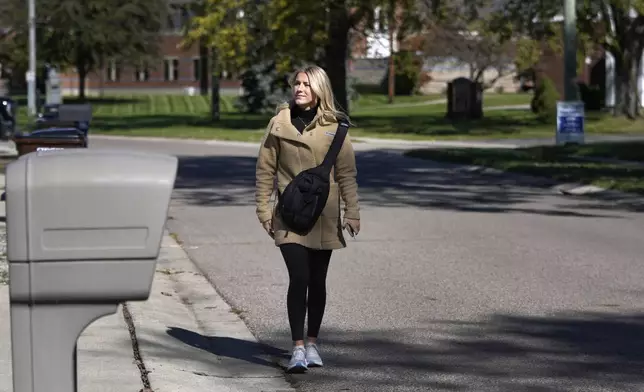 Republican Rylee Linting walks door to door campaigning hoping to unseat Democratic State Rep. Jaime Churches, Wednesday, Oct. 16, 2024, in Gibraltar, Mich. (AP Photo/Carlos Osorio)