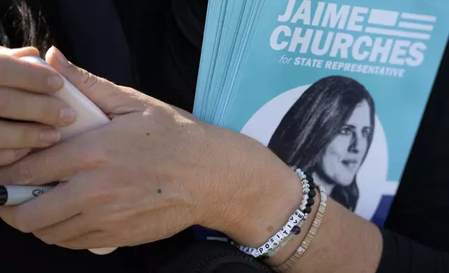 Democratic state Rep. Jaime Churches goes door to door campaigning as she seeks a second term in the state House, Friday, Oct. 11, 2024, in Trenton, Mich. (AP Photo/Carlos Osorio)