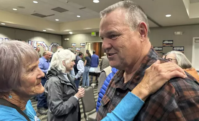 Sen. Jon Tester, a Democrat from Montana seeking re-election to a fourth term, speaks with a supporter during campaign rally in a hotel ballroom, Oct. 25, 2024, in Bozeman, Mont. (AP Photo/Matthew Brown)