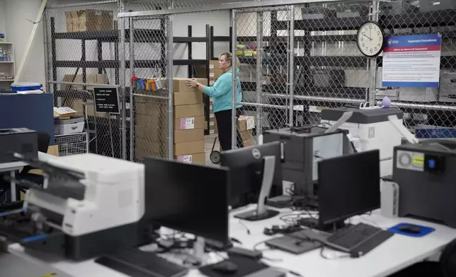 Cari-Ann Burgess, interim Registrar of Voters for Washoe County, Nev., moves around boxes while preparing the office for elections Saturday, Sept. 21, 2024, in Reno, Nev. (AP Photo/John Locher)