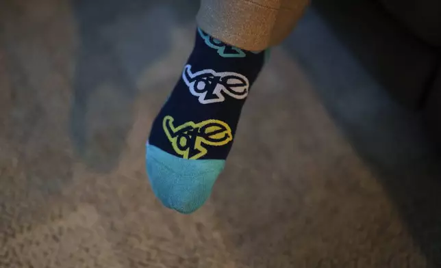 Cari-Ann Burgess, interim Registrar of Voters for Washoe County, Nev., wears socks with the word "vote" while sitting at her home Friday, Sept. 20, 2024, in Reno, Nev. (AP Photo/John Locher)