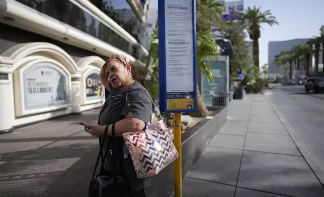 Haydee Zetino waits for the bus after working a shift as a maid at Harrah's hotel-casino along the Las Vegas Strip, Thursday, Sept. 12, 2024, in Las Vegas. Zetino, an immigrant from El Salvador, gained temporary protected status since arriving in the wake of a major earthquake in 2001. (AP Photo/John Locher)