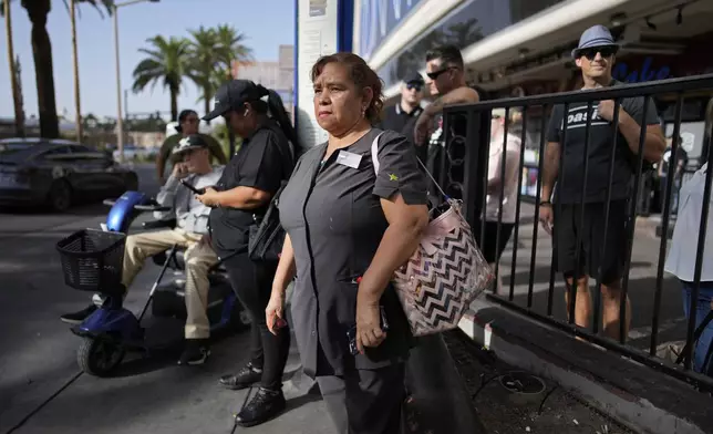 Haydee Zetino waits for the bus after working a shift as a maid at Harrah's hotel-casino along the Las Vegas Strip, Thursday, Sept. 12, 2024, in Las Vegas. Zetino, an immigrant from El Salvador, gained temporary protected status since arriving in the wake of a major earthquake in 2001. (AP Photo/John Locher)