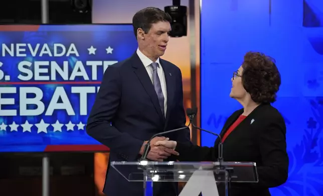 Republican senatorial candidate Sam Brown, left, and Sen. Jacky Rosen, D-Nev., shake hands before a debate, Thursday, Oct. 17, 2024, in Las Vegas. (AP Photo/John Locher)