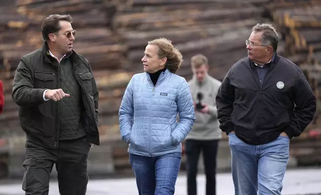 Joyce Craig, Democratic candidate for governor, talks with Mark Brady, administrator of Coos County, left, and Paul Grenier, former mayor of Berlin, N.H., during a visit to the Milan Lumber mill, Wednesday, Oct. 16, 2024, in Milan, N.H. (AP Photo/Robert F. Bukaty)