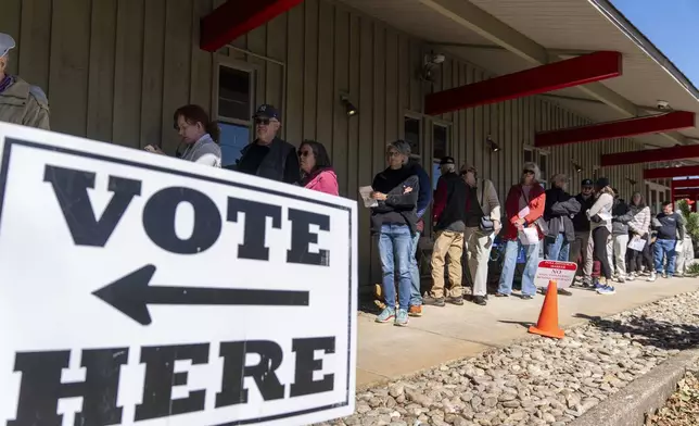 People stand in line at a polling place on the first day of early in-person voting in Black Mountain, N.C., Thursday, Oct. 17, 2024. (AP Photo/Stephanie Scarbrough)