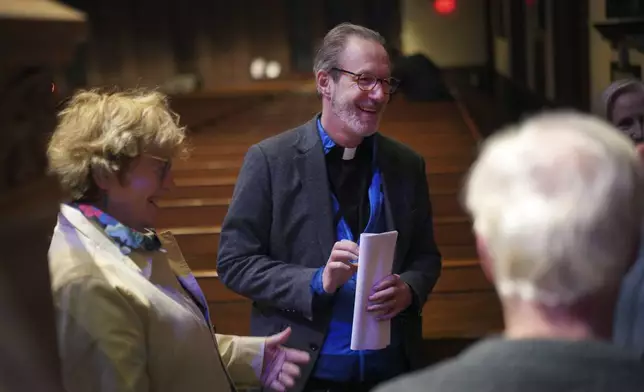 Cordelia Moyse, left, and her husband, the Rev. David Peck, talk with attendees after the weekly "Contemplative Citizenship" service at St. James Episcopal Church in Lancaster, Pa., on Tuesday, Oct. 15, 2024. (AP Photo/Jessie Wardarski)