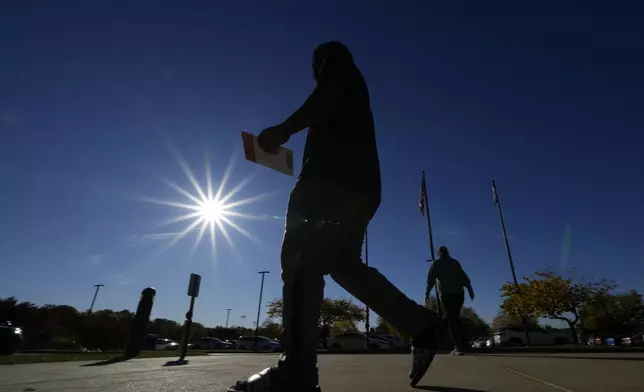 A voter returns their mail-in ballot for the 2024 General Election in the United States outside the Chester County Government Services Center, Friday, Oct. 25, 2024, in West Chester, Pa. (AP Photo/Matt Slocum)