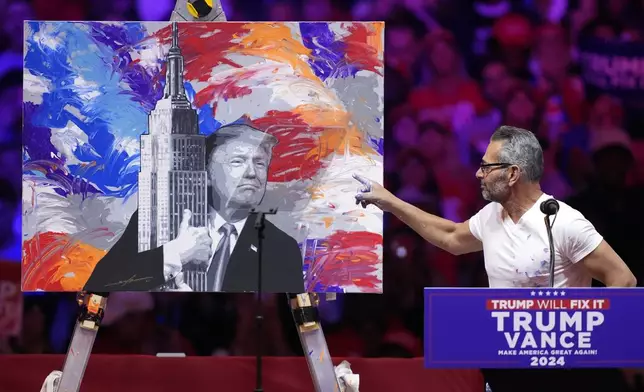 Scott Lobaido unveils a painting before Republican presidential nominee former President Donald Trump speaks at a campaign rally at Madison Square Garden, Sunday, Oct. 27, 2024, in New York. (AP Photo/Evan Vucci)