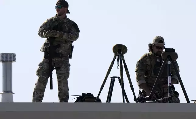 Law enforcement snipers look out from a roof before Republican presidential nominee former President Donald Trump arrives to speak at a campaign rally at Dodge County Airport, Sunday, Oct. 6, 2024, in Juneau, Wis. (AP Photo/Julia Demaree Nikhinson)