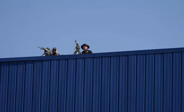 Law enforcement snipers sit on a roof before Republican presidential nominee former President Donald Trump arrives to speak at a campaign rally at Dodge County Airport, Sunday, Oct. 6, 2024, in Juneau, Wis. (AP Photo/Julia Demaree Nikhinson)