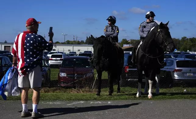 Law enforcement on horseback watch as supporters arrive before Republican presidential nominee former President Donald Trump speaks at a campaign rally at the Butler Farm Show, Saturday, Oct. 5, 2024, in Butler, Pa. (AP Photo/Julia Demaree Nikhinson)