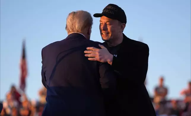 Republican presidential nominee former President Donald Trump hugs Elon Musk at a campaign rally at the Butler Farm Show, Saturday, Oct. 5, 2024, in Butler, Pa. (AP Photo/Evan Vucci)