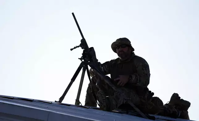 A counter sniper sets up on the roof of a building before Republican presidential nominee former President Donald Trump speaks at a campaign rally at the Butler Farm Show, the site where a gunman tried to assassinate him in July, Saturday, Oct. 5, 2024, in Butler, Pa. (AP Photo/Alex Brandon)