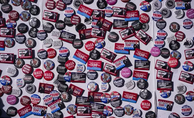 Vendors buttons for sale are pictured ahead of a Republican presidential nominee former President Donald Trump campaign rally, Saturday, Oct. 19, 2024, at Arnold Palmer Regional Airport in Latrobe, Pa. (AP Photo/Matt Rourke)