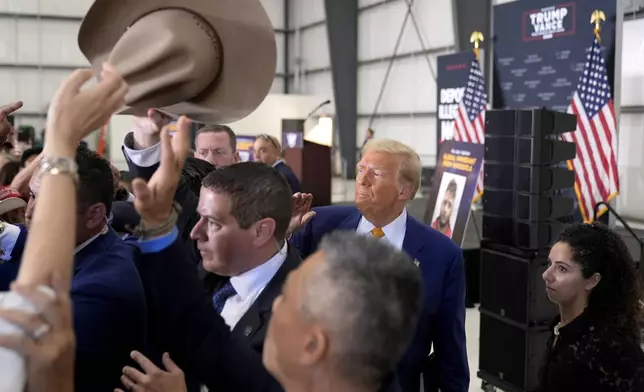 Republican presidential nominee former President Donald Trump, second right, greets attendees as he departs a news conference at Austin-Bergstrom International Airport, Friday, Oct. 25, 2024, in Austin, Texas. (AP Photo/Alex Brandon)