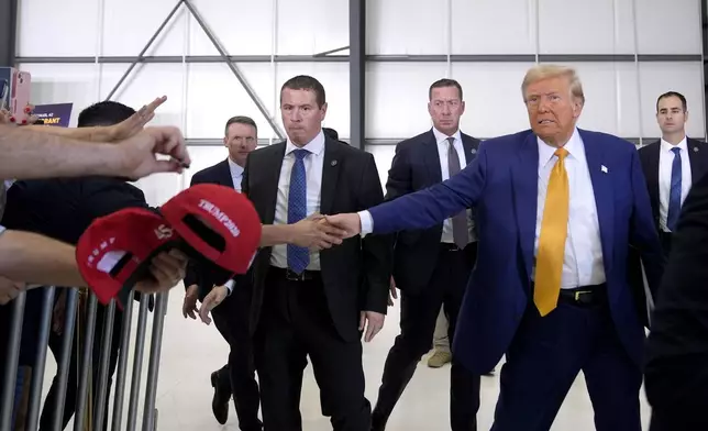 Republican presidential nominee former President Donald Trump shakes hands with an attendee as he departs a news conference at Austin-Bergstrom International Airport, Friday, Oct. 25, 2024, in Austin, Texas. (AP Photo/Alex Brandon)