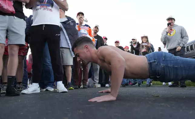 Jacob Tampa does pushups to try and warm up as people arrive and wait in line before Republican presidential nominee former President Donald Trump speaks at the Butler Farm Show, the site where a gunman tried to assassinate him in July, Saturday, Oct. 5, 2024, in Butler, Pa. (AP Photo/Alex Brandon)