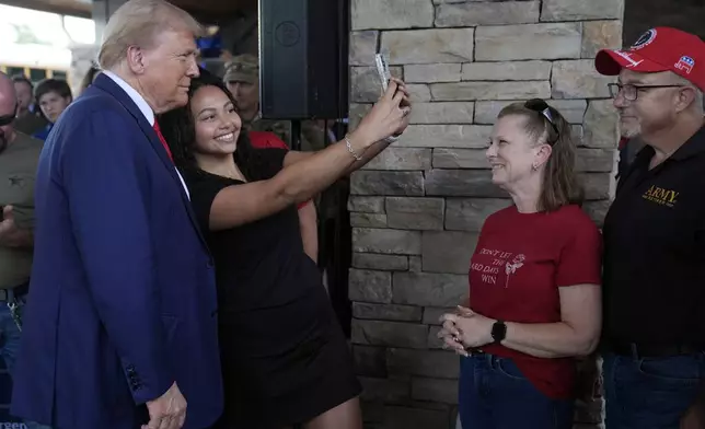 Republican presidential nominee former President Donald Trump greets people at a temporary relief shelter as he visits areas impacted by Hurricane Helene, Friday, Oct. 4, 2024, in Evans, Ga. (AP Photo/Evan Vucci)