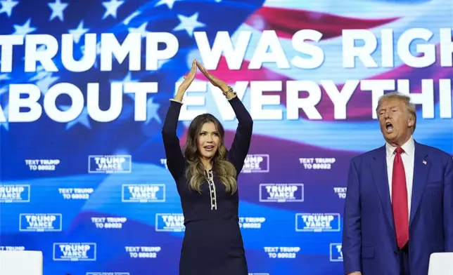 Republican presidential nominee former President Donald Trump watches as South Dakota Gov. Kristi Noem dances to the song "Y.M.C.A." at a campaign town hall at the Greater Philadelphia Expo Center &amp; Fairgrounds, Monday, Oct. 14, 2024, in Oaks, Pa. (AP Photo/Alex Brandon)