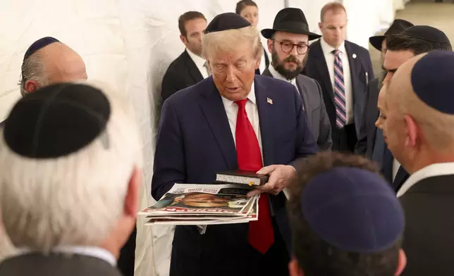 Republican presidential nominee former President Donald Trump talks with members of the Chabad Lubavitch after visiting the gravesite of Rabbi Menachem Mendel Schneerson, Monday, Oct. 7, 2024, in New York. (AP Photo/Yuki Iwamura)