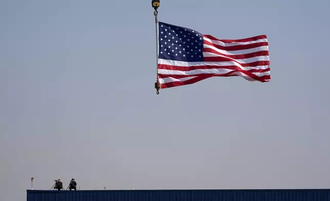 Law enforcement snipers sit on a roof before Republican presidential nominee former President Donald Trump arrives to speak at a campaign rally at Dodge County Airport, Sunday, Oct. 6, 2024, in Juneau, Wis. (AP Photo/Julia Demaree Nikhinson)