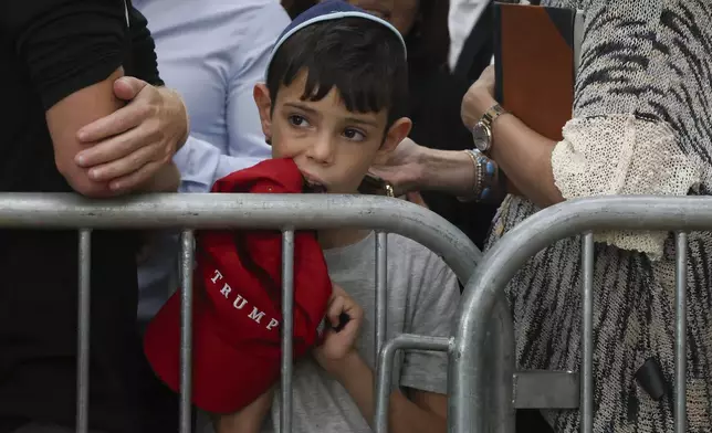 A boy awaits the arrival of Republican presidential nominee former President Donald Trump at Ohel Chabad-Lubavitch, Monday, Oct. 7, 2024, in New York. (AP Photo/Yuki Iwamura)