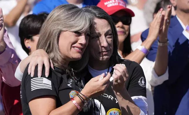 Kelly Comperatore-Meeder, left, and Dawn Comperatore-Schafer, sisters of firefighter Corey Comperatore, who died as he shielded family members from gunfire, cry at a campaign event for Republican presidential nominee former President Donald Trump, at the Butler Farm Show, the site where a gunman tried to assassinate Trump in July, Saturday, Oct. 5, 2024, in Butler, Pa. (AP Photo/Alex Brandon)