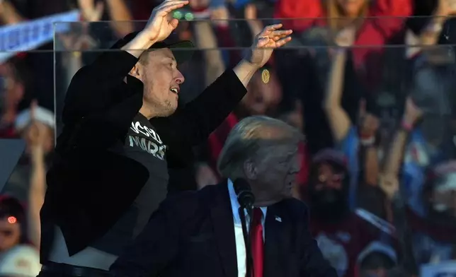 Elon Musk jumps on the stage behind Republican presidential nominee former President Donald Trump during a campaign rally at the Butler Farm Show, Saturday, Oct. 5, 2024, in Butler, Pa. (AP Photo/Julia Demaree Nikhinson)