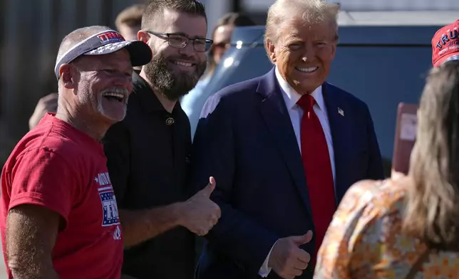 Republican presidential nominee former President Donald Trump poses for a photo as he arrives at Detroit Metropolitan Wayne County Airport, Friday, Oct. 18, 2024, in Detroit. (AP Photo/Evan Vucci)