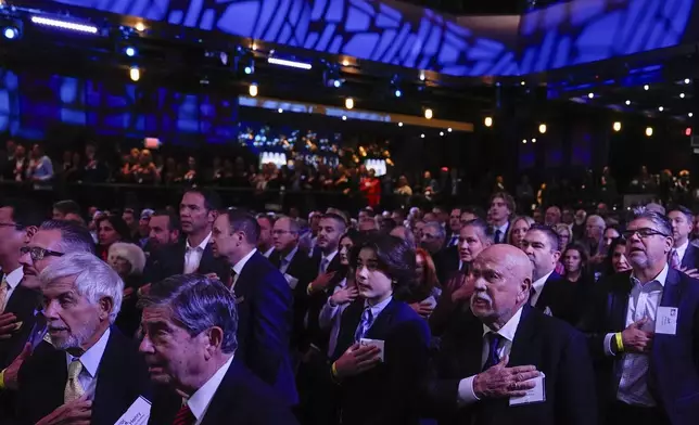 Members of the Detroit Economic Club stand for the pledge of allegiance prior to a speech by Republican presidential nominee former President Donald Trump, Thursday, Oct. 10, 2024, in Detroit. (AP Photo/Julia Demaree Nikhinson)