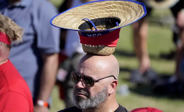 An attendee, with ice in his hat to cool off, attends a campaign rally for Republican presidential nominee former President Donald Trump at the Calhoun Ranch, Saturday, Oct. 12, 2024, in Coachella, Calif. (AP Photo/Alex Brandon)