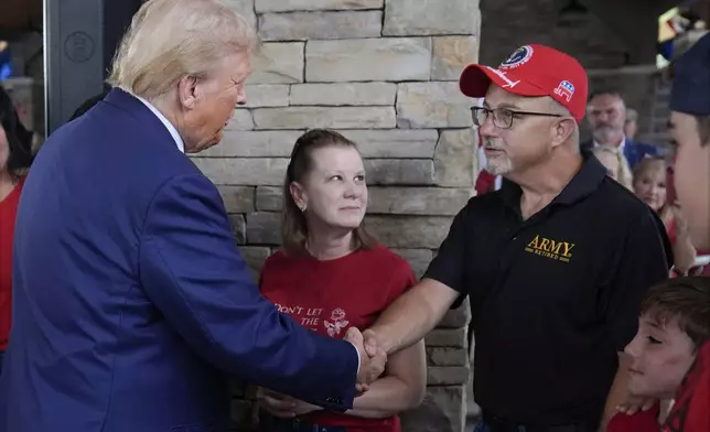 Republican presidential nominee former President Donald Trump greets people at a temporary relief shelter as he visits areas impacted by Hurricane Helene, Friday, Oct. 4, 2024, in Evans, Ga. (AP Photo/Evan Vucci)