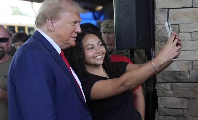 Republican presidential nominee former President Donald Trump greets people at a temporary relief shelter as he visits areas impacted by Hurricane Helene, Friday, Oct. 4, 2024, in Evans, Ga. (AP Photo/Evan Vucci)