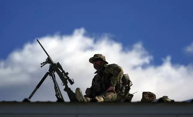 Law enforcement provides overwatch on a roof as supporters arrive before Republican presidential nominee former President Donald Trump speaks at a campaign rally at the Butler Farm Show, Saturday, Oct. 5, 2024, in Butler, Pa. (AP Photo/Julia Demaree Nikhinson)