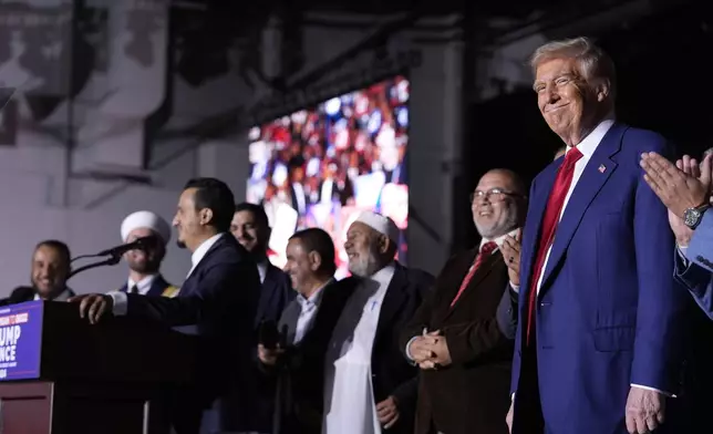 Republican presidential nominee former President Donald Trump, right, looks on as local Muslim leaders speak during a campaign rally at the Suburban Collection Showplace, Saturday, Oct. 26, 2024, in Novi, Mich. (AP Photo/Alex Brandon)