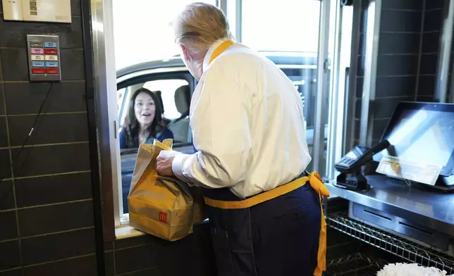 Republican presidential nominee former President Donald Trump hands an order to an employee at the drive-thru window during a visit to McDonald's in Feasterville-Trevose, Pa., Sunday, Oct. 20, 2024. (Doug Mills/The New York Times via AP, Pool)