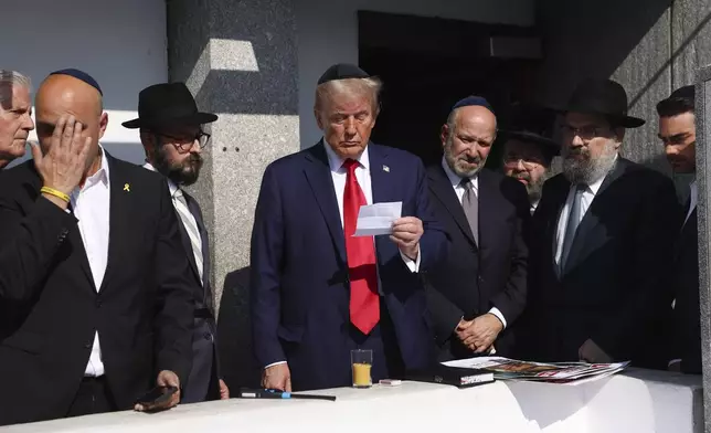 Republican presidential nominee former President Donald Trump, center, visits the gravesite of Rabbi Menachem Mendel Schneerson at Ohel Chabad-Lubavitch, Monday, Oct. 7, 2024, in New York. (AP Photo/Yuki Iwamura)