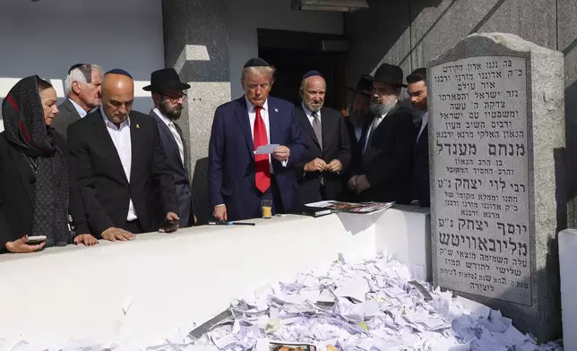 Republican presidential nominee former President Donald Trump, center, visits the gravesite of Rabbi Menachem Mendel Schneerson at Ohel Chabad-Lubavitch, Monday, Oct. 7, 2024, in New York. (AP Photo/Yuki Iwamura)